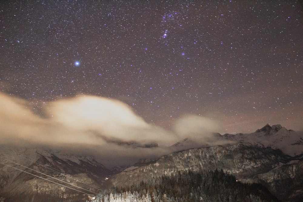 snow covered mountain under starry night