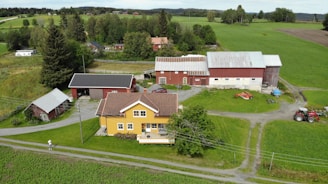 Farmer shaking hands with a financial advisor in front of a rural property.