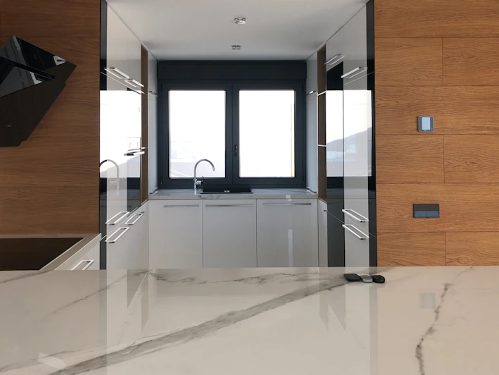 A sleek modern kitchen featuring minimalist white Viking kitchen cabinets with clean lines and integrated handles.