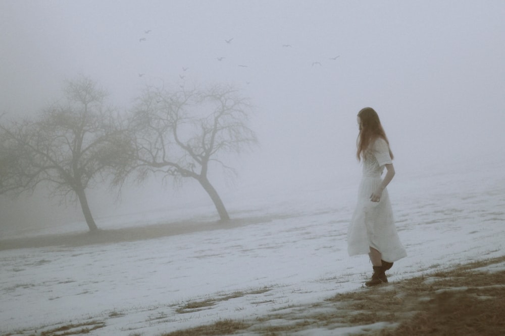 woman in white dress standing on snow covered ground