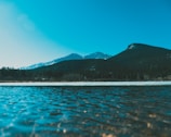 body of water near mountain during daytime