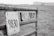 A close-up of a metal gate with two weathered signs displaying numbers 9830 and 9832. The gate is rusty and situated in a grassy area with a blurred background, suggesting an outdoor rural setting.