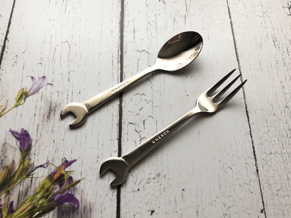 silver spoon and fork on white wooden table