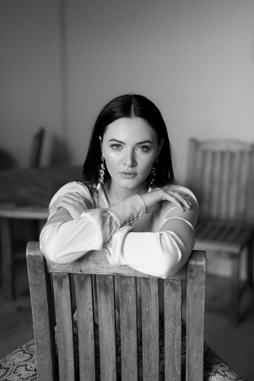 grayscale photo of woman in long sleeve shirt sitting on bench