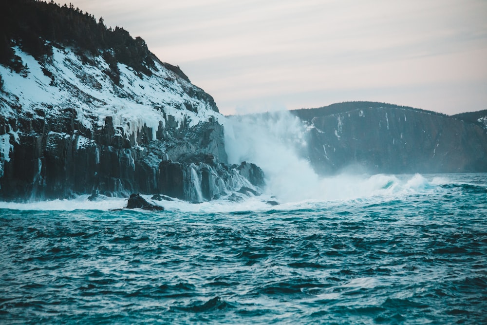 ocean waves crashing on rocky shore during daytime