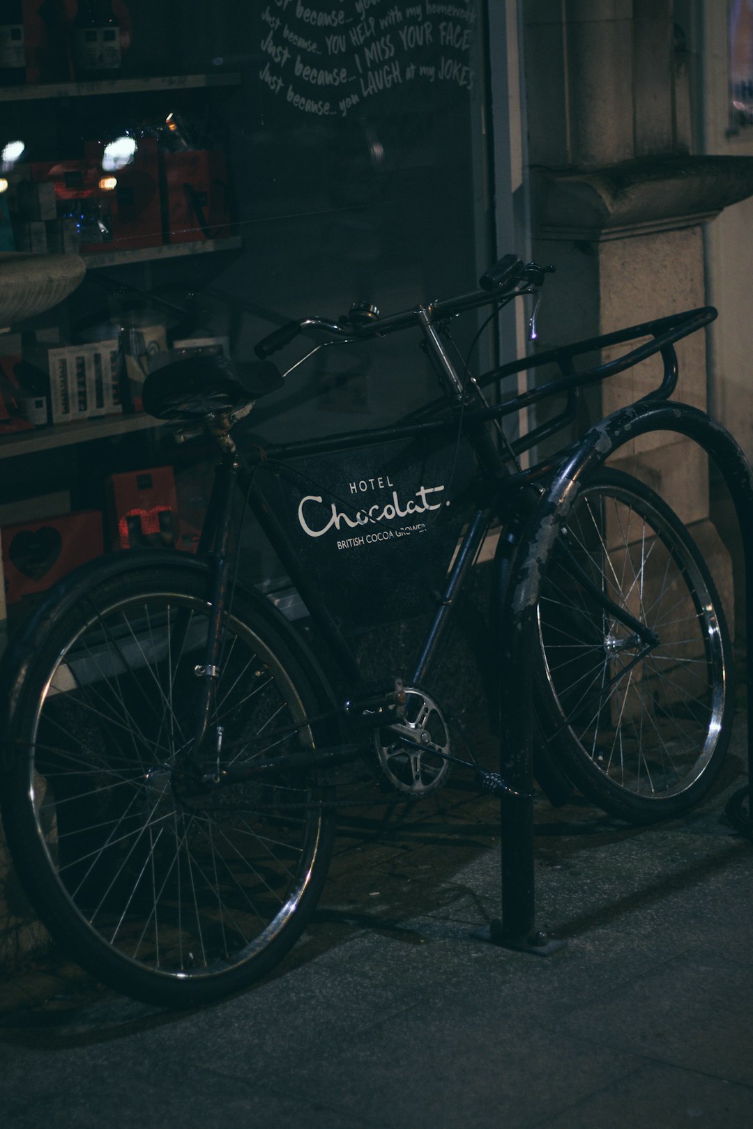 black city bicycle parked beside black metal fence