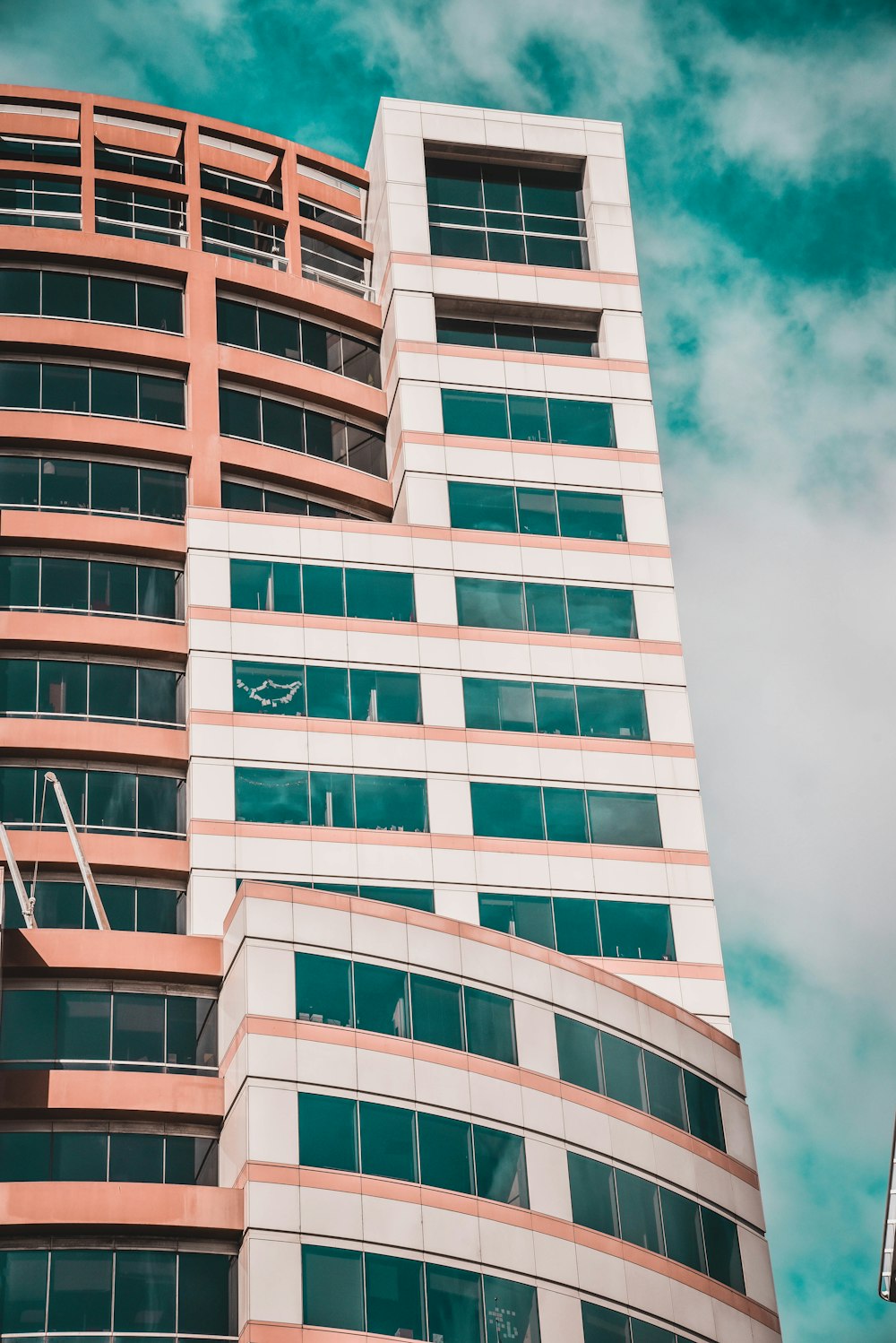 white and green concrete building under white clouds and blue sky during daytime