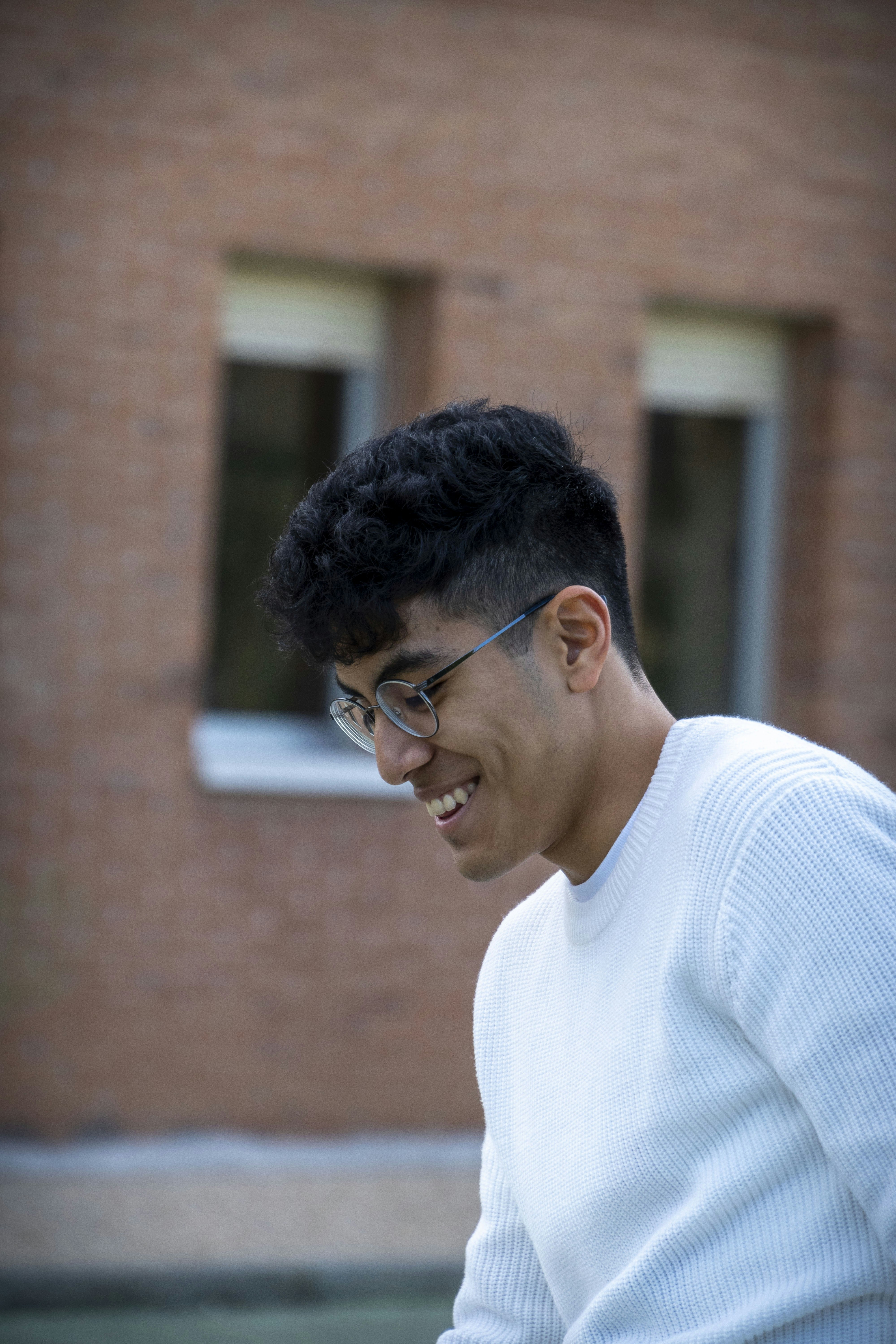 man in white crew neck sweater wearing black framed eyeglasses