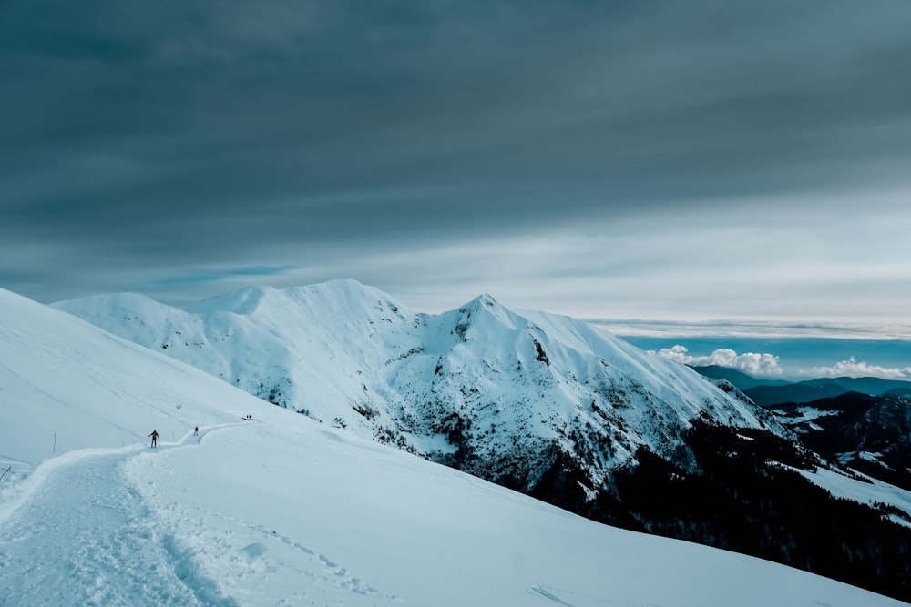 montagne enneigée sous un ciel nuageux pendant la journée