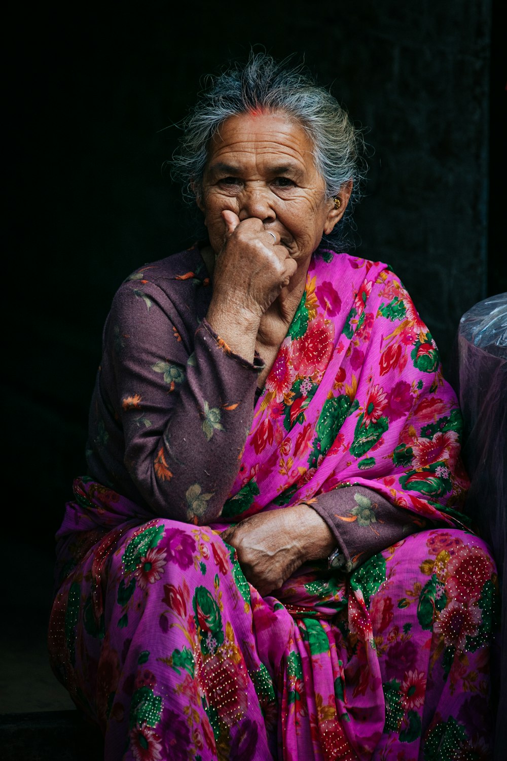 woman in pink and brown floral dress sitting