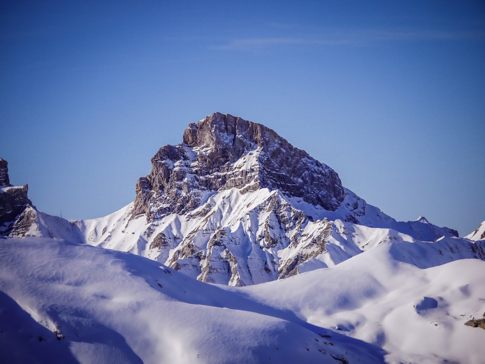 montagne enneigée sous ciel bleu pendant la journée