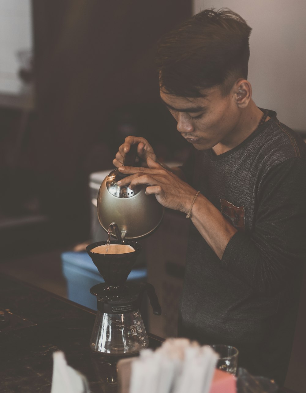 man in black crew neck t-shirt holding black ceramic bowl