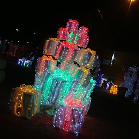 A festive display of assorted fireworks boxes and gift packs glowing under warm lighting.