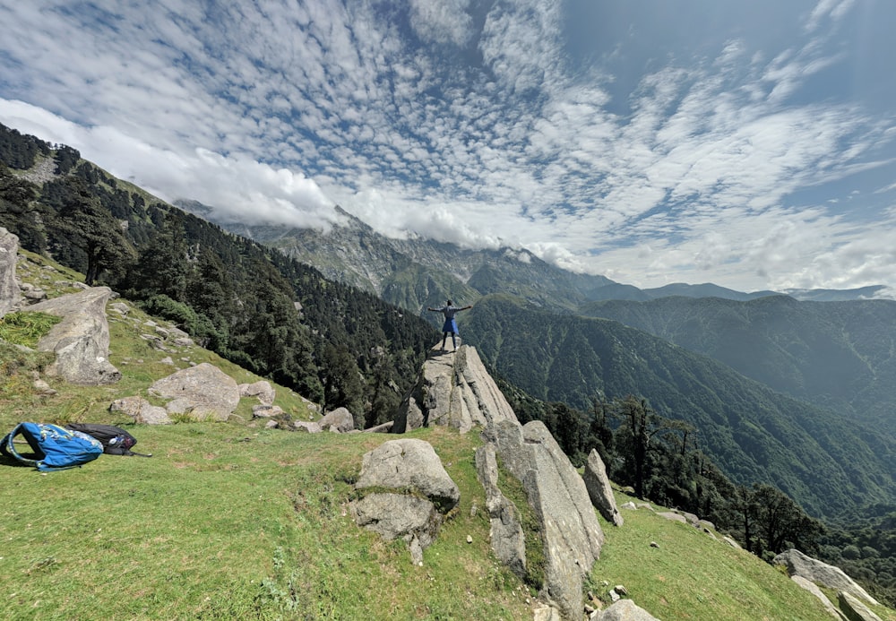 昼間、灰色の岩層の上に立っている人