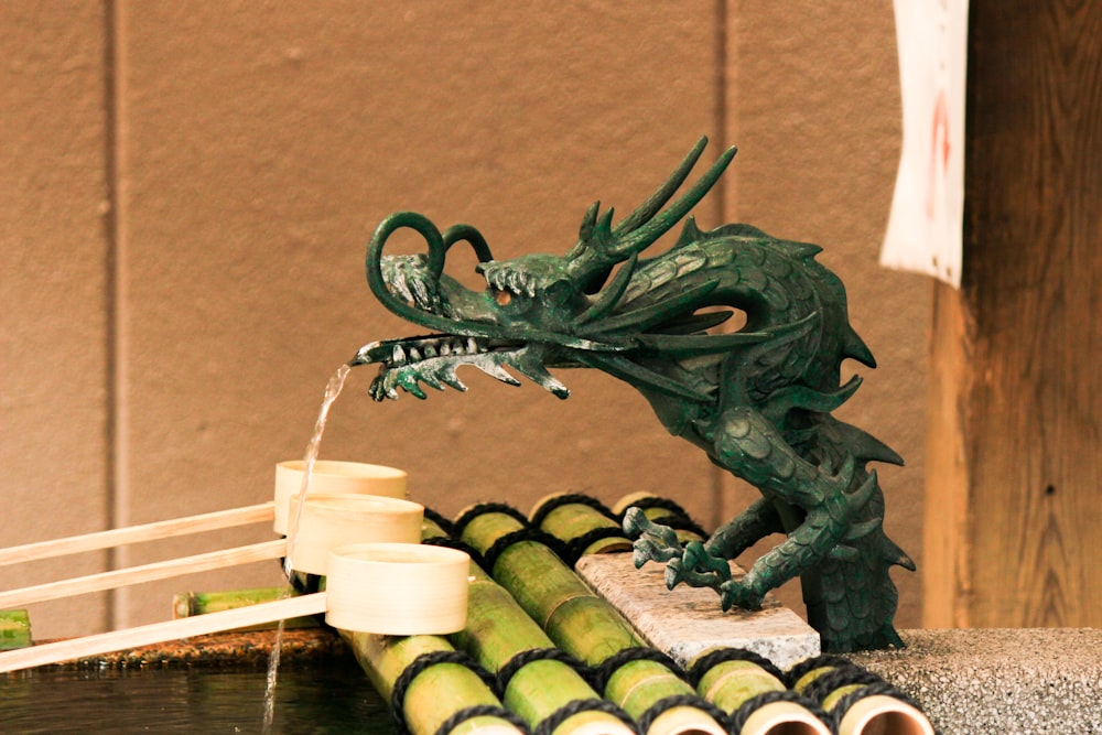 green dragon figurine beside white candles