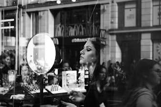 woman in black long sleeve shirt standing near glass window
