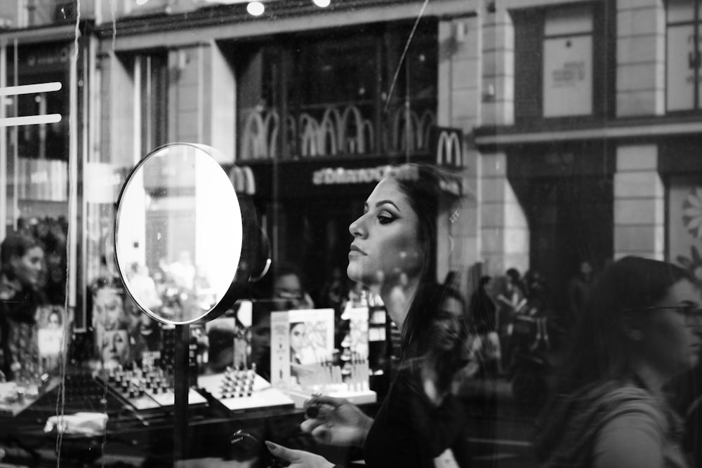 woman in black long sleeve shirt standing near glass window