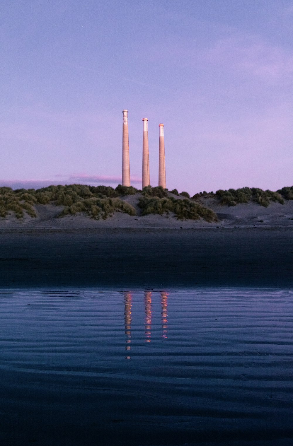 brown and white metal posts on brown rock formation near body of water during daytime