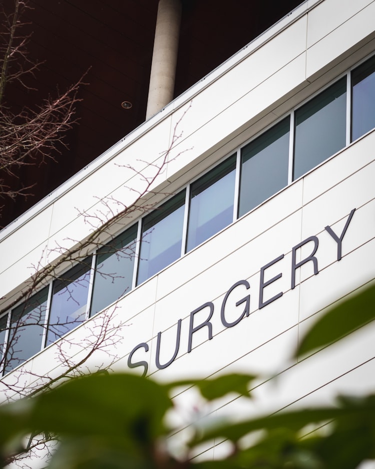 outside hospital building wall with sign saying surgery