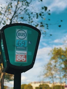Bus stop sign 'Ecole Veterinaire' with green surroundings.
