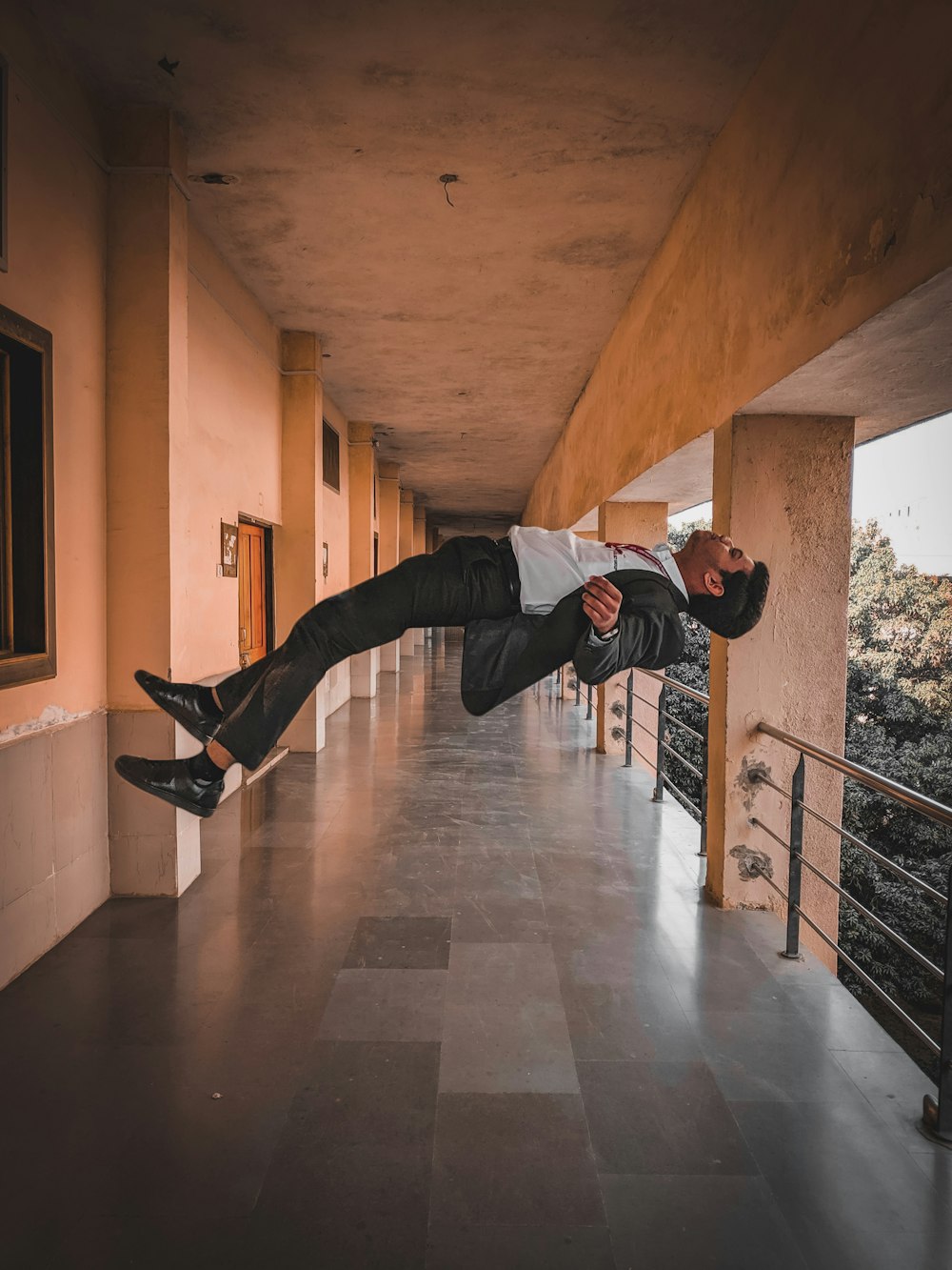 man in black jacket and black pants jumping on brown wooden floor