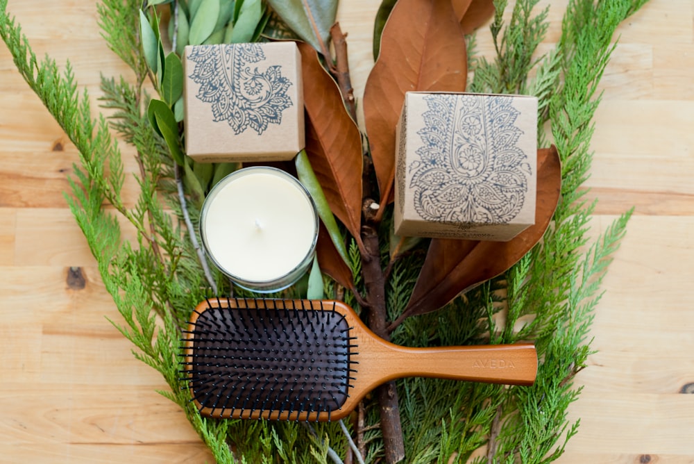 brown wooden hair brush beside white round plate on brown wooden table