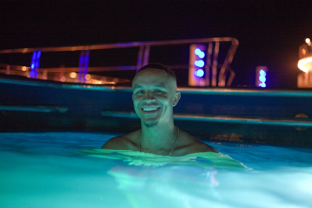 man in swimming pool during night time