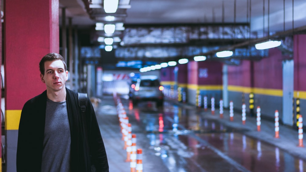 person in black coat walking on street during night time