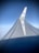 A view of an airplane wing with a clear blue sky in the background. The KLM logo is visible on the winglet, and there is a reflection of light on the smooth surface of the wing.