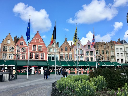 People walking on street near brown and green concrete building during daytime — Bruges, Belgium