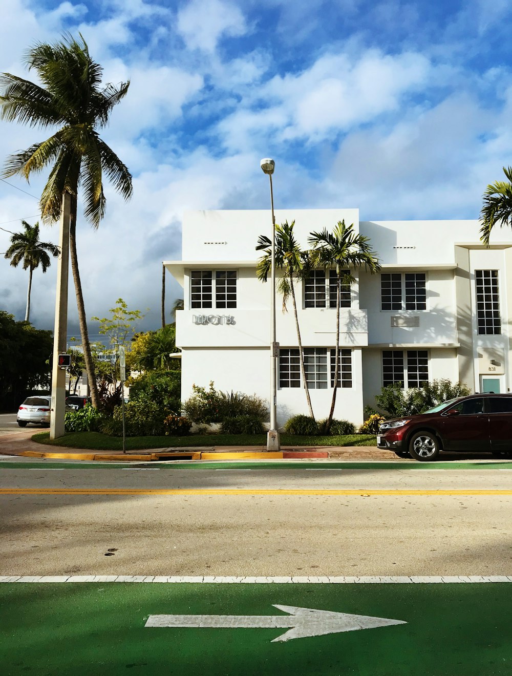 red car parked in front of white concrete building