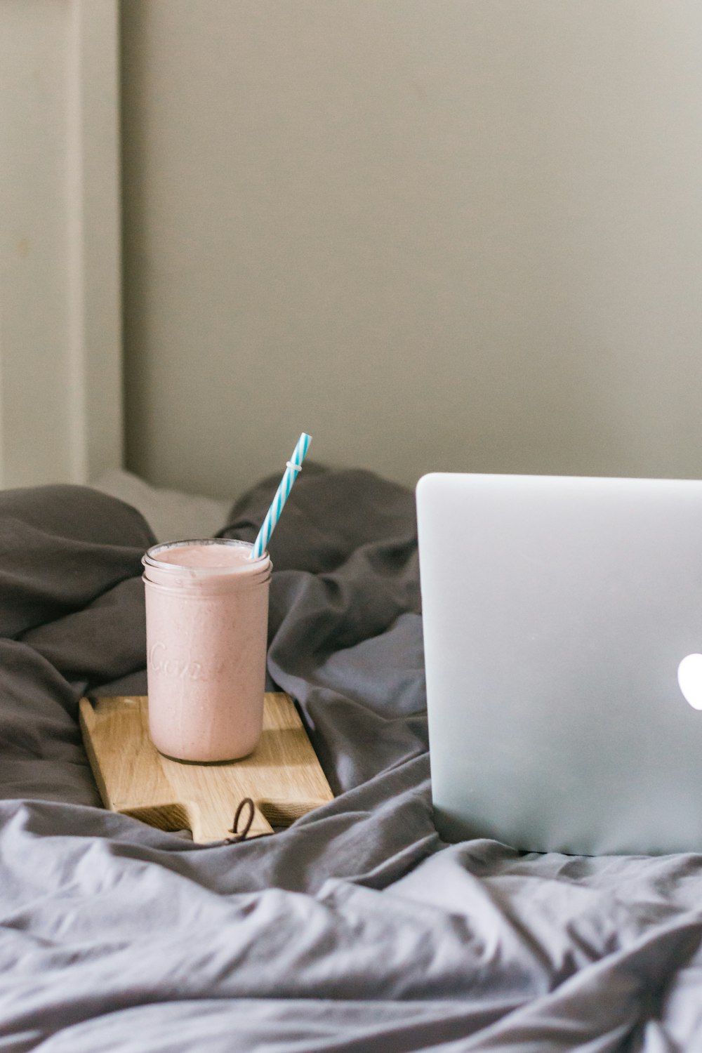 white plastic cup with purple straw on silver macbook