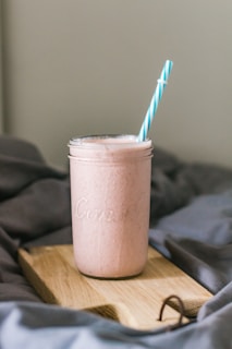 A diabetic-friendly shake in a mason jar with a striped straw, set against a light beige background