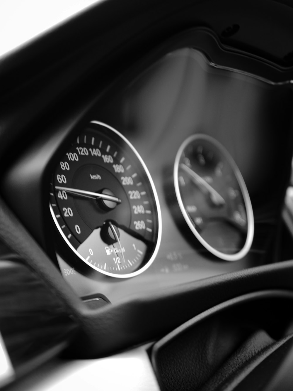 grayscale photo of car speedometer