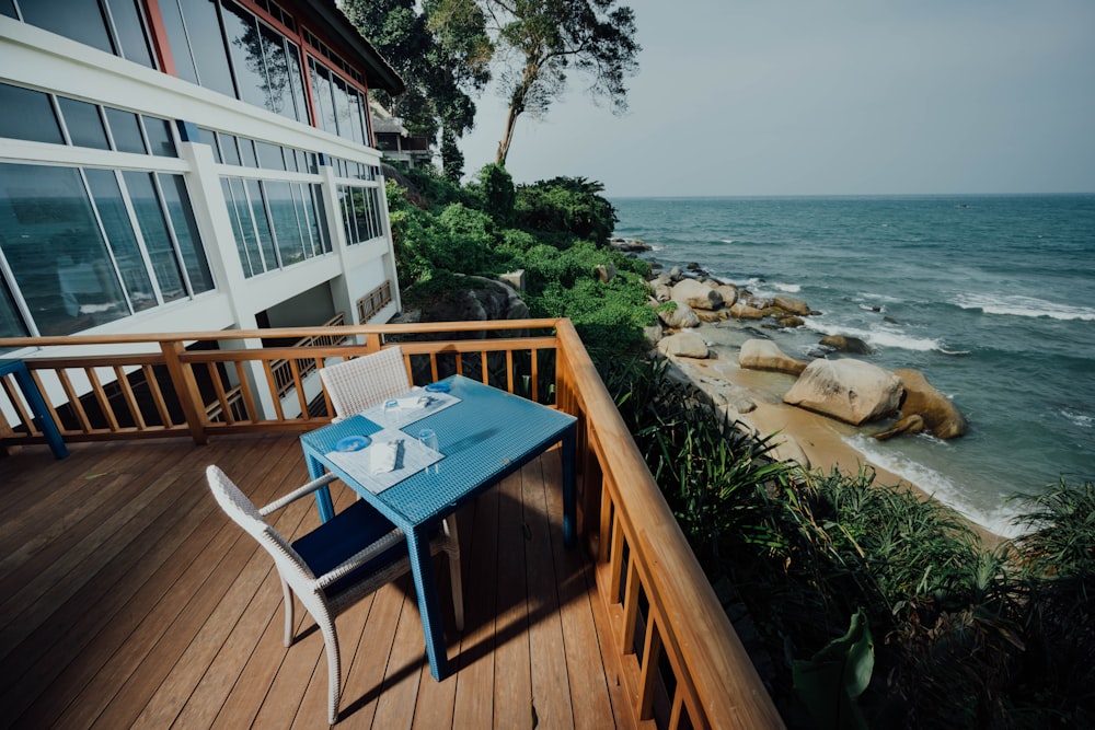 blue and brown wooden table on brown wooden deck near body of water during daytime