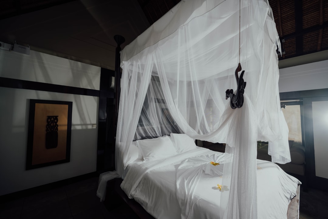 white bed linen with black headphones,