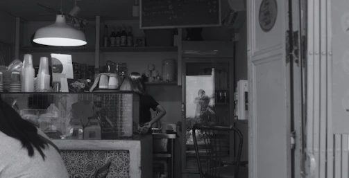 A friendly Cupmate staff member assisting a customer at a sleek grab-and-go counter.