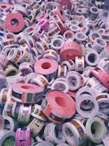A collection of colorful tickets or coupons rolled into cylinders, with various denominations and text visible on each roll. The tickets are stacked in a chaotic and overlapping manner, showcasing a range of colors and patterns.