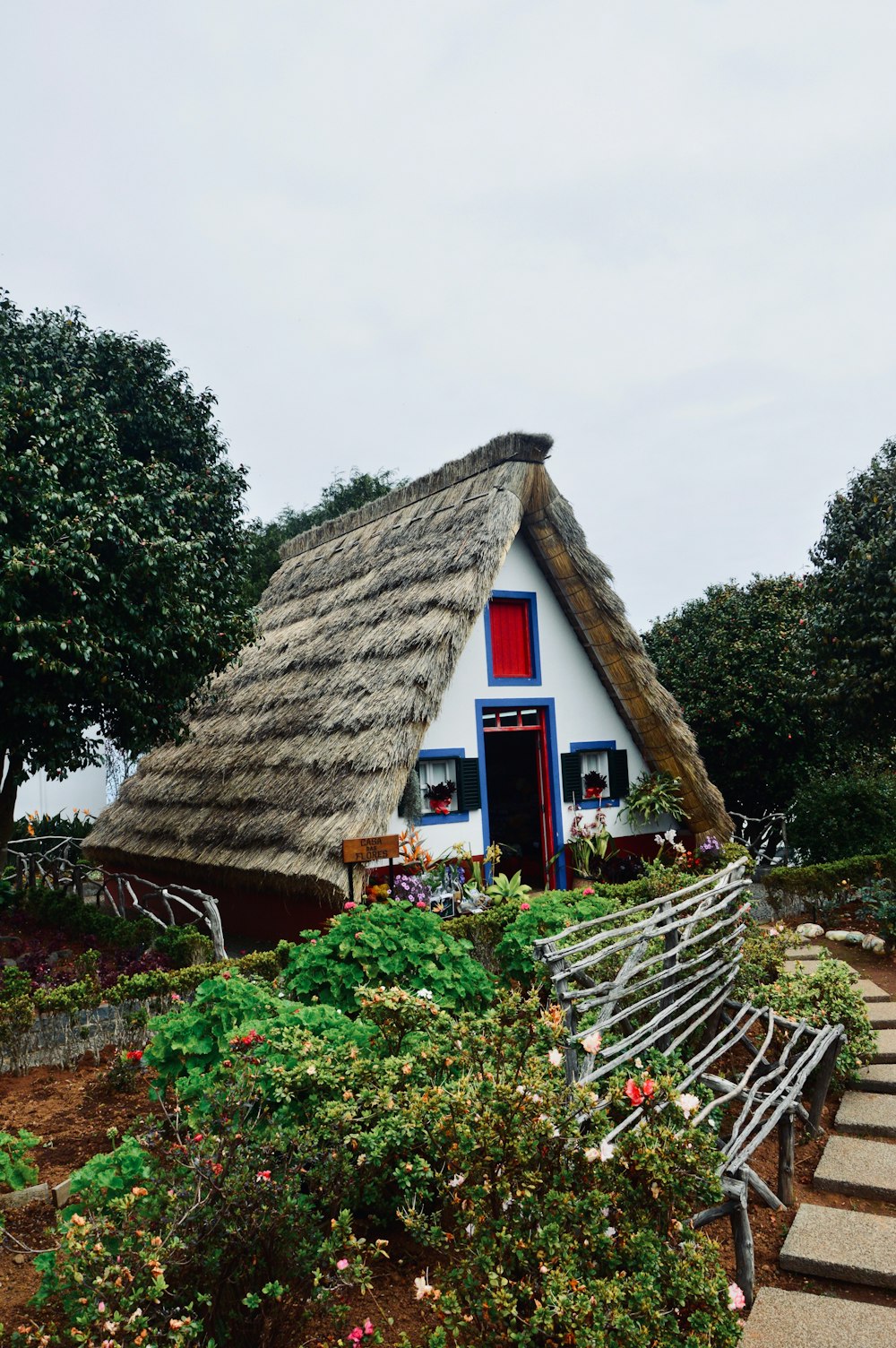 maison en bois marron près des arbres verts sous le ciel blanc pendant la journée