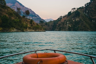 brown boat on water near mountain during daytime