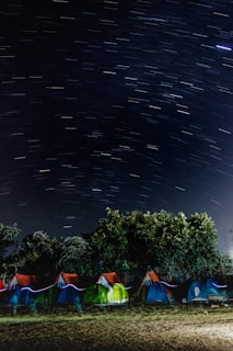 Colorful tents set up under a starry night sky.