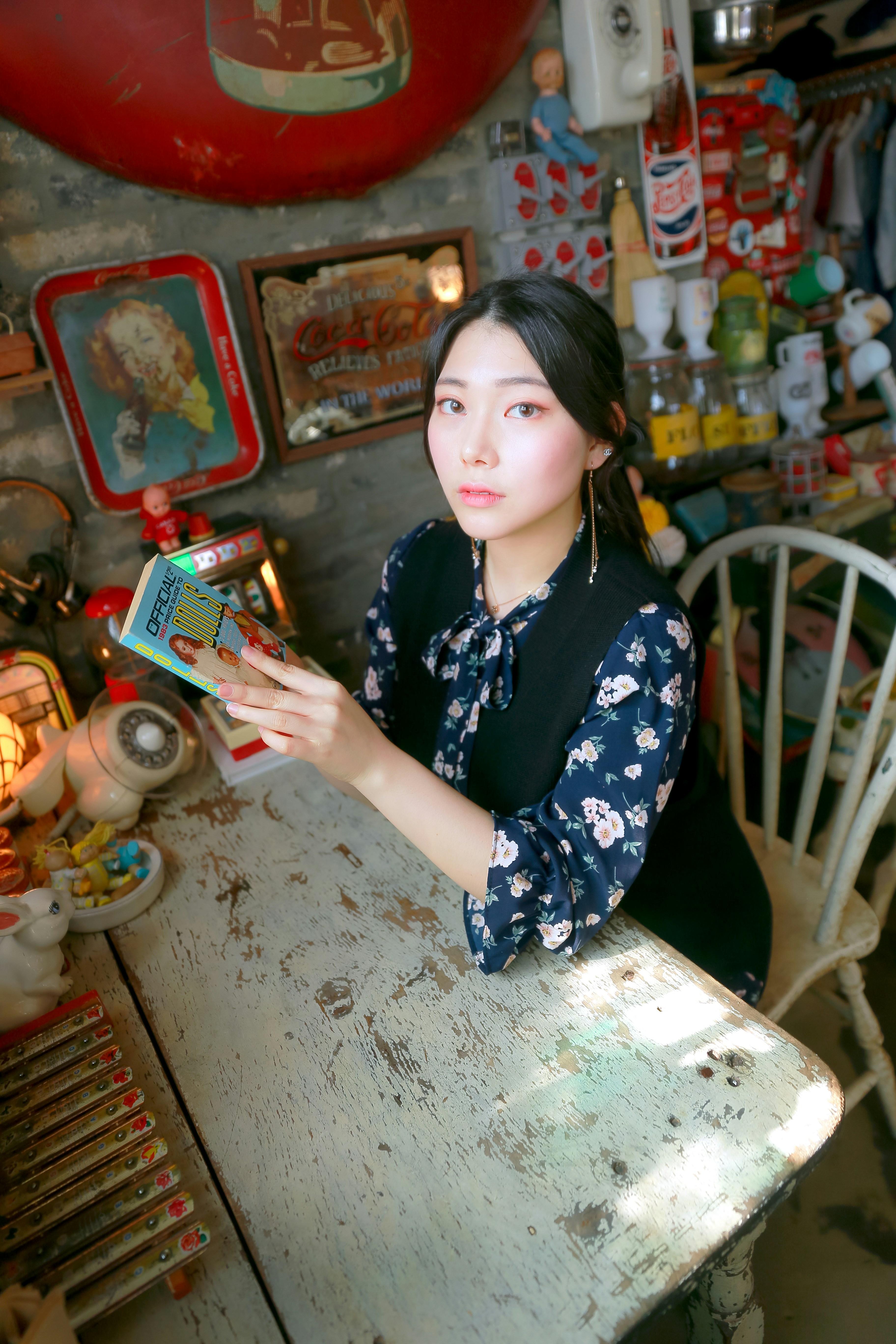 woman in black and white floral dress sitting on white plastic chair