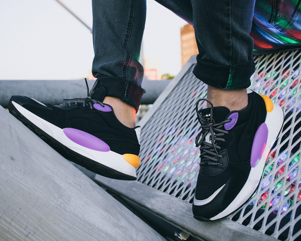 person wearing black and purple nike sneakers