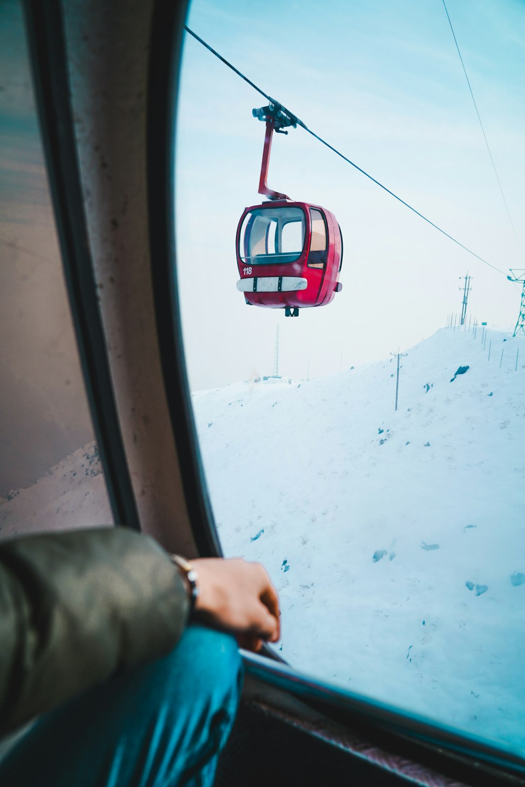 person in gray jacket driving red cable car during daytime