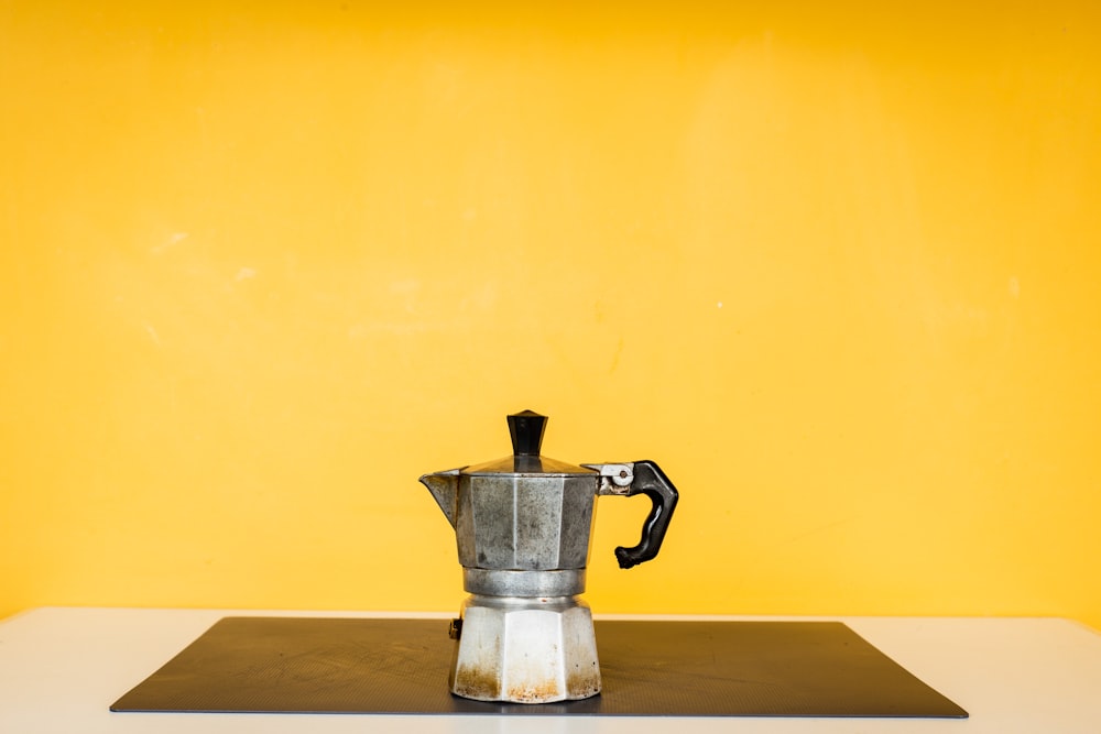 stainless steel teapot on brown wooden table