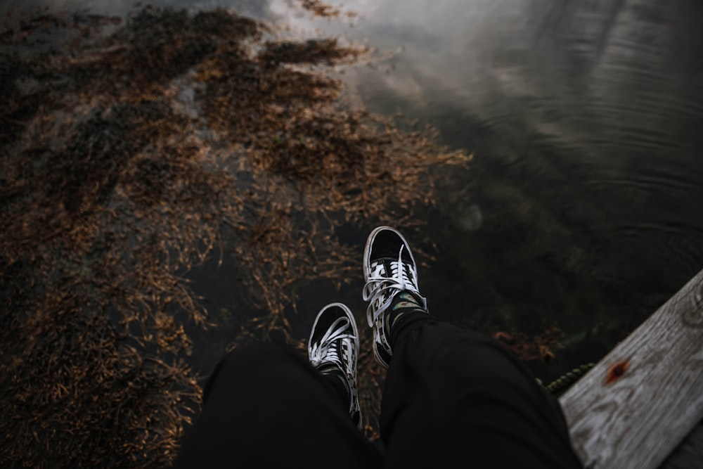 person in black pants and black and white sneakers