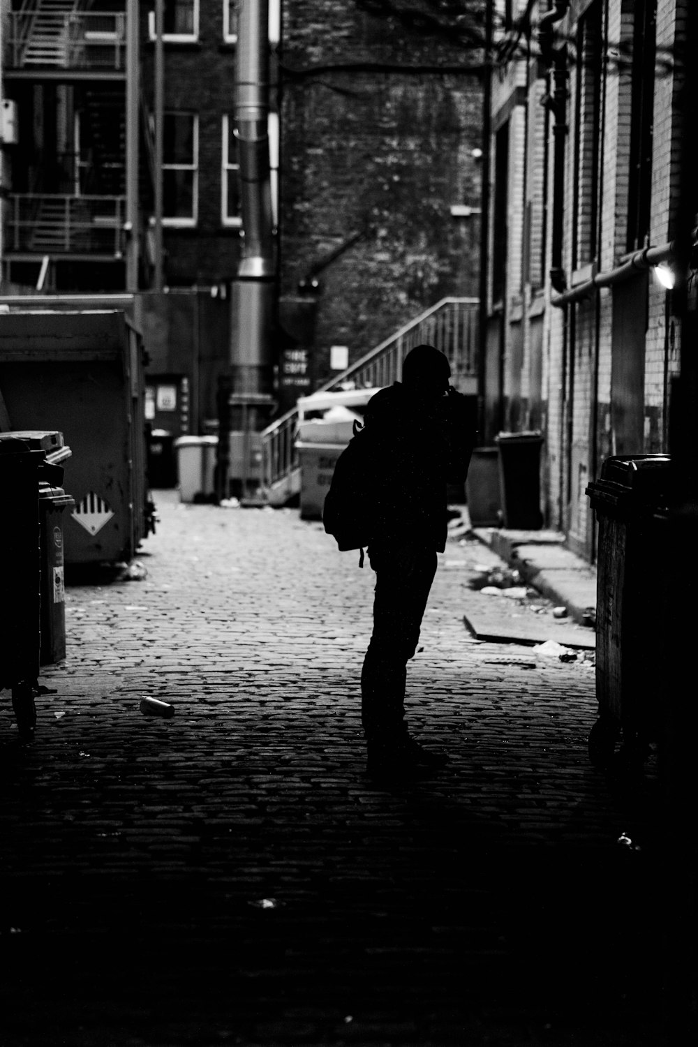 man in black jacket walking on sidewalk during daytime