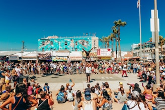 people sitting on white plastic chairs during daytime