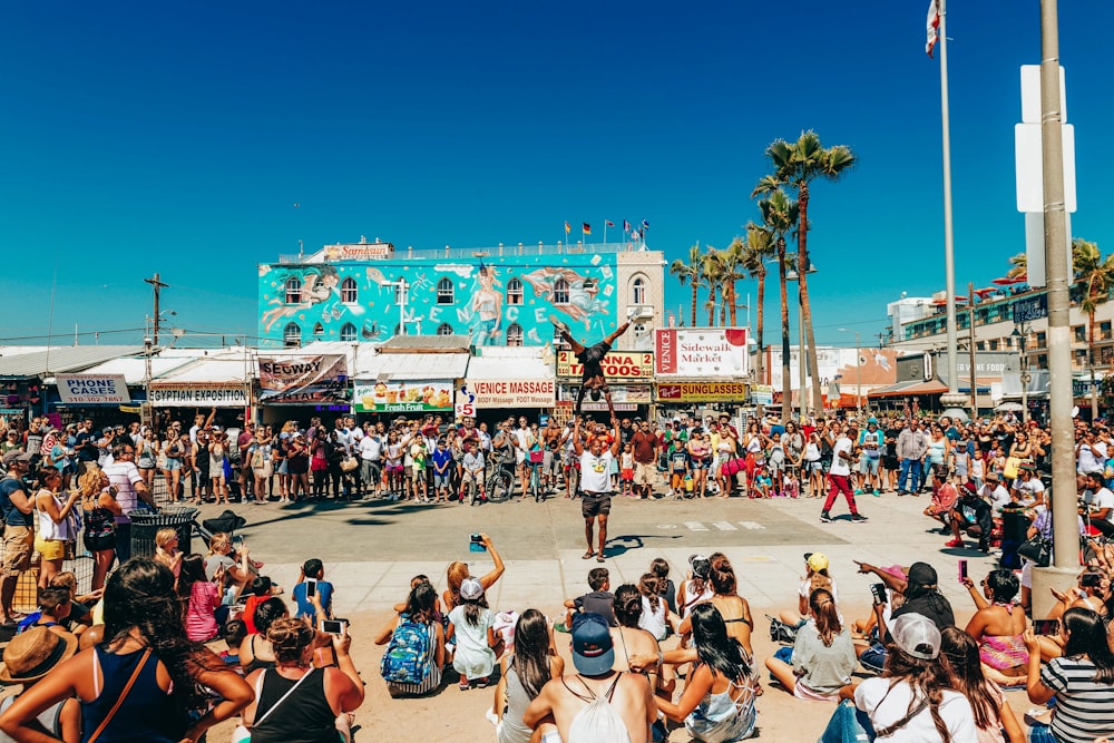 people sitting on white plastic chairs during daytime