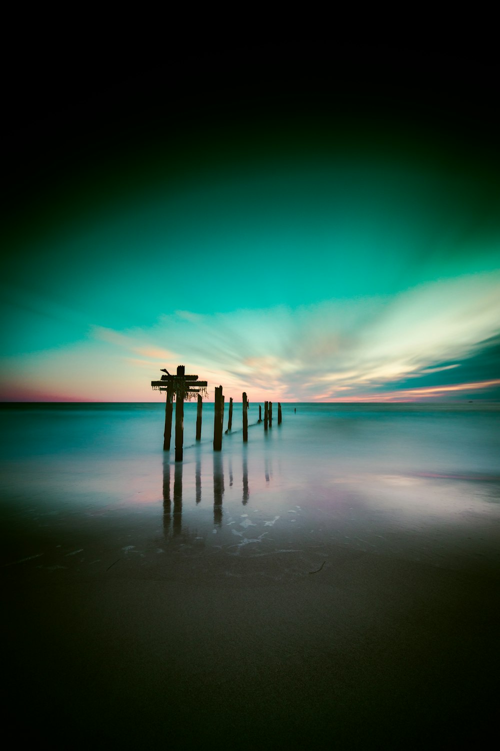 pontile di legno marrone sullo specchio d'acqua durante la notte